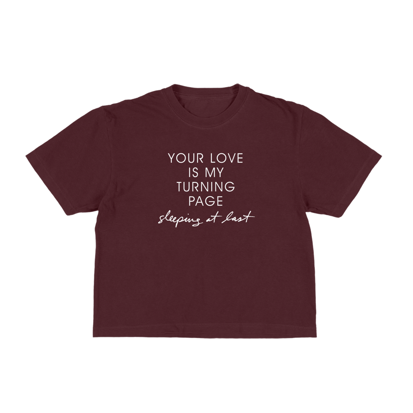 A maroon short-sleeve t-shirt with white printed text on the front reading 'YOUR LOVE IS MY TURNING PAGE sleeping at last'
